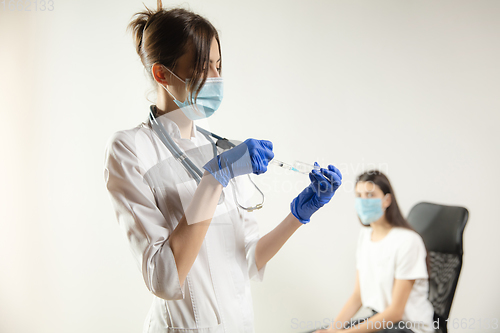 Image of Doctor or nurse giving vaccine to patient using the syringe injected in hospital