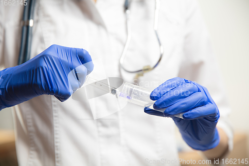 Image of Doctor or nurse giving vaccine to patient using the syringe injected in hospital