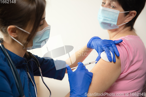 Image of Close up doctor or nurse giving vaccine to patient using the syringe injected in hospital