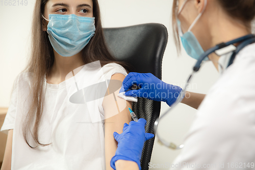 Image of Close up doctor or nurse giving vaccine to patient using the syringe injected in hospital