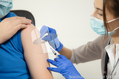 Image of Close up doctor or nurse giving vaccine to patient using the syringe injected in hospital