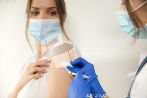 Image of Close up doctor or nurse giving vaccine to patient using the syringe injected in hospital