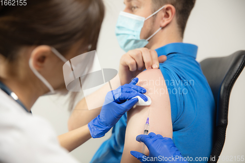 Image of Close up doctor or nurse giving vaccine to patient using the syringe injected in hospital