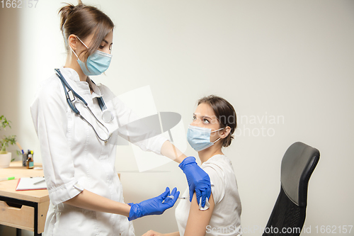Image of Close up doctor or nurse giving vaccine to patient using the syringe injected in hospital