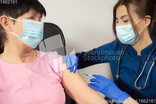 Image of Close up doctor or nurse giving vaccine to patient using the syringe injected in hospital