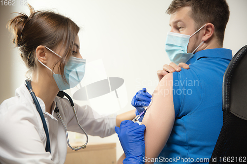 Image of Close up doctor or nurse giving vaccine to patient using the syringe injected in hospital