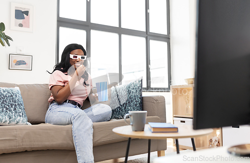 Image of happy african american woman watching tv at home