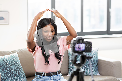 Image of female blogger with camera video blogging at home