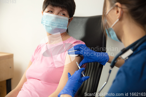 Image of Close up doctor or nurse giving vaccine to patient using the syringe injected in hospital