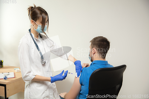 Image of Close up doctor or nurse giving vaccine to patient using the syringe injected in hospital