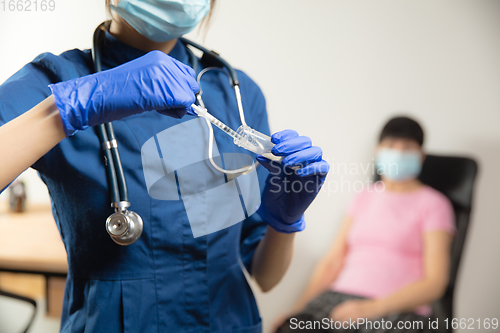 Image of Doctor or nurse giving vaccine to patient using the syringe injected in hospital