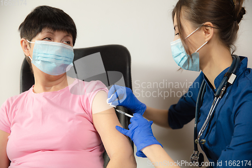 Image of Close up doctor or nurse giving vaccine to patient using the syringe injected in hospital