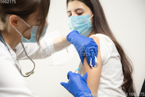 Image of Close up doctor or nurse giving vaccine to patient using the syringe injected in hospital