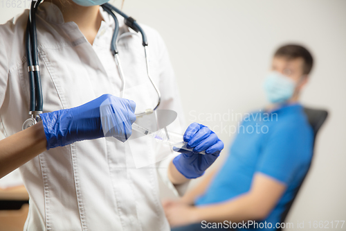 Image of Doctor or nurse giving vaccine to patient using the syringe injected in hospital