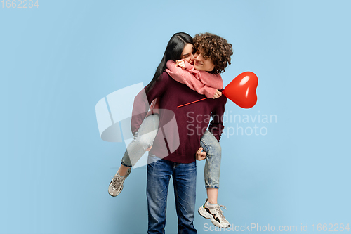 Image of Beautiful couple in love on blue studio background. Valentine\'s Day, love and emotions concept