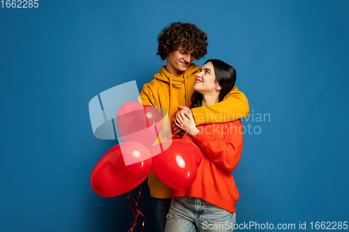 Image of Beautiful couple in love on blue studio background. Valentine\'s Day, love and emotions concept