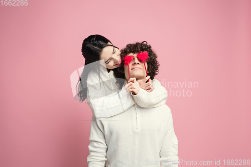 Image of Young, beautiful couple in love on pink studio background. Valentine\'s Day, love and emotions concept