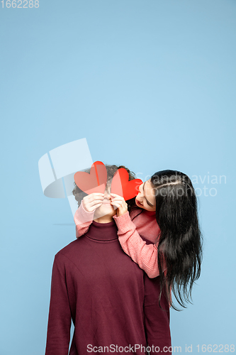 Image of Beautiful couple in love on blue studio background. Valentine\'s Day, love and emotions concept