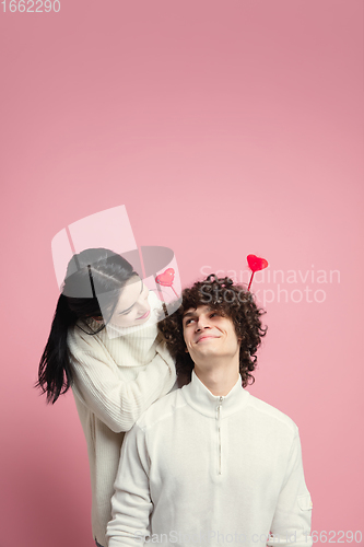 Image of Young, beautiful couple in love on pink studio background. Valentine\'s Day, love and emotions concept