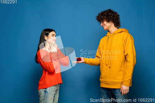 Image of Beautiful couple in love on blue studio background. Valentine\'s Day, love and emotions concept