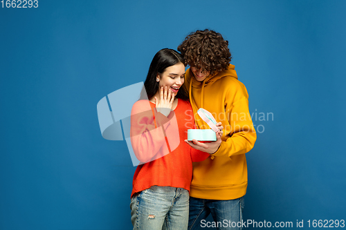 Image of Beautiful couple in love on blue studio background. Valentine\'s Day, love and emotions concept