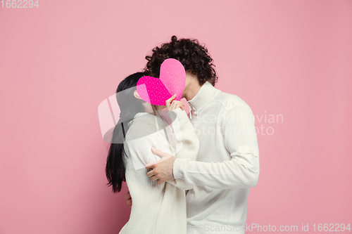 Image of Young, beautiful couple in love on pink studio background. Valentine\'s Day, love and emotions concept