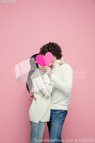 Image of Young, beautiful couple in love on pink studio background. Valentine\'s Day, love and emotions concept