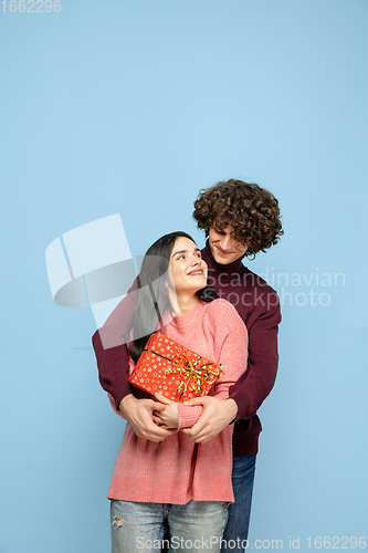 Image of Beautiful couple in love on blue studio background. Valentine\'s Day, love and emotions concept