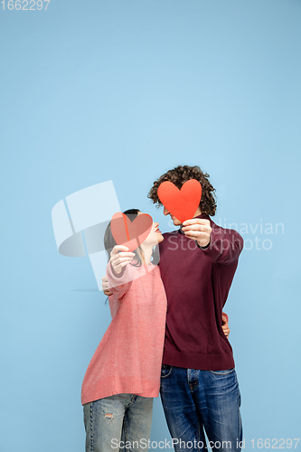 Image of Beautiful couple in love on blue studio background. Valentine\'s Day, love and emotions concept