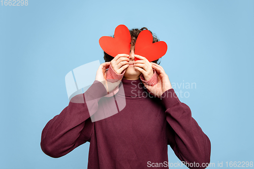 Image of Beautiful couple in love on blue studio background. Valentine\'s Day, love and emotions concept