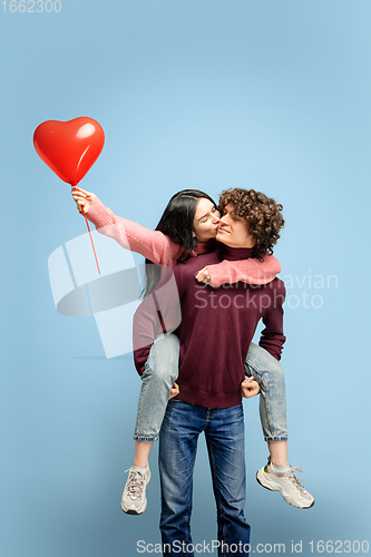 Image of Beautiful couple in love on blue studio background. Valentine\'s Day, love and emotions concept