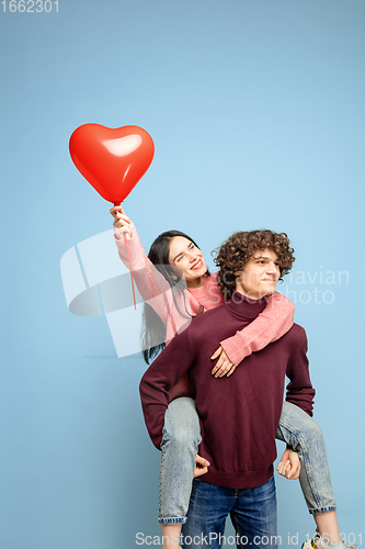 Image of Beautiful couple in love on blue studio background. Valentine\'s Day, love and emotions concept