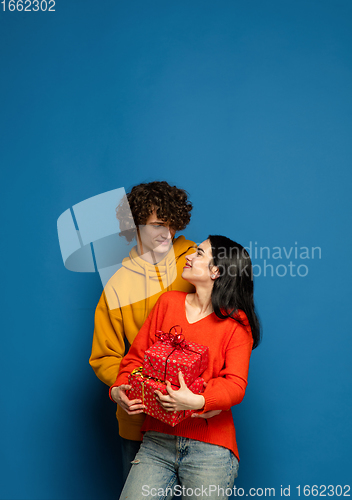 Image of Beautiful couple in love on blue studio background. Valentine\'s Day, love and emotions concept