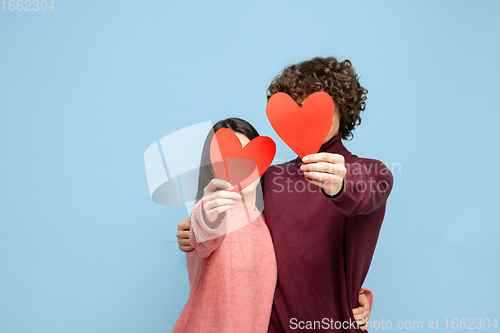 Image of Beautiful couple in love on blue studio background. Valentine\'s Day, love and emotions concept