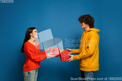 Image of Beautiful couple in love on blue studio background. Valentine\'s Day, love and emotions concept