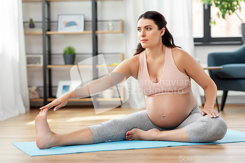 Image of happy pregnant woman doing sports at home