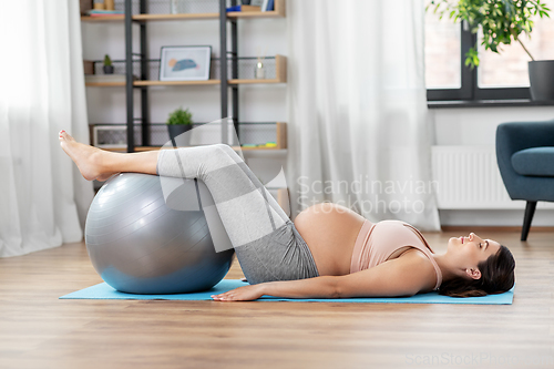 Image of pregnant woman training with fitness ball at home