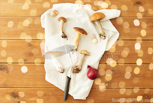 Image of edible mushrooms, kitchen knife and towel