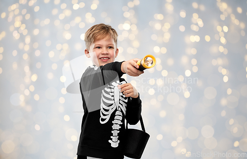 Image of boy with candies and flashlight on halloween