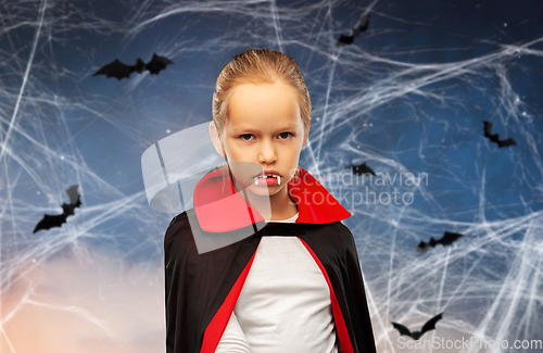 Image of girl in dracula costume with cape on halloween