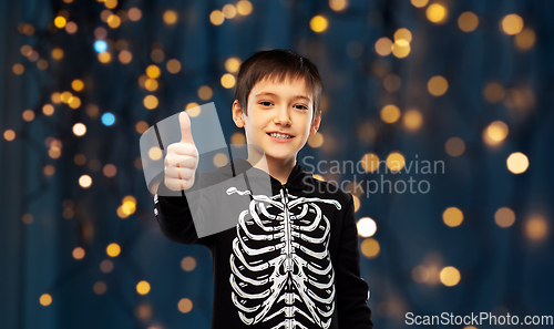 Image of boy in halloween skeleton costume shows thumbs up