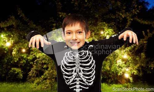 Image of boy in halloween costume of skeleton frightening