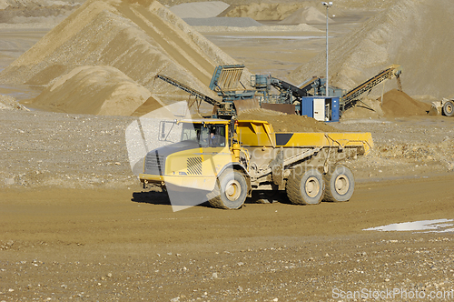 Image of Yellow dump truck working in gravel pit