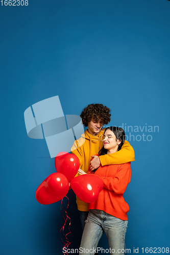 Image of Beautiful couple in love on blue studio background. Valentine\'s Day, love and emotions concept