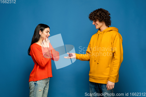 Image of Beautiful couple in love on blue studio background. Valentine\'s Day, love and emotions concept