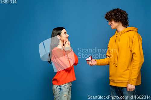 Image of Beautiful couple in love on blue studio background. Valentine\'s Day, love and emotions concept