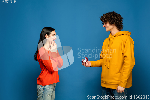 Image of Beautiful couple in love on blue studio background. Valentine\'s Day, love and emotions concept