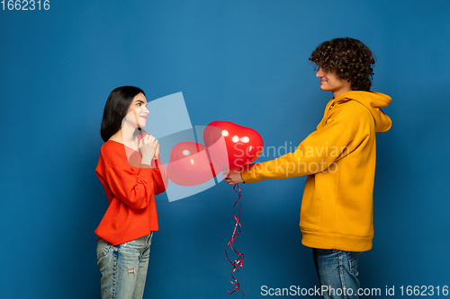 Image of Beautiful couple in love on blue studio background. Valentine\'s Day, love and emotions concept