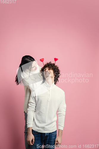 Image of Young, beautiful couple in love on pink studio background. Valentine\'s Day, love and emotions concept