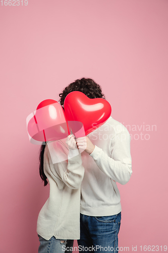 Image of Young, beautiful couple in love on pink studio background. Valentine\'s Day, love and emotions concept